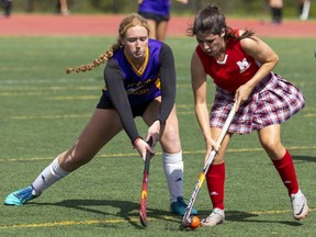 East Elgin's Mya Farr and Medway's Ava Donohue fight for the ball on Tuesday Sept. 19, 2023 in one of the first games of the high school athletic year, won by Medway 4-0. Field hockey is trying out a two-tier system this year in a bid to cut down on lopsided scores, an official said. (Mike Hensen/The London Free Press)