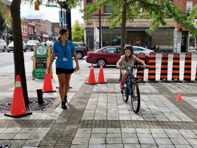 Josephine Furtner, 9, of Owen Sound rides in the bike safety rodeo accompanied by Laine Nissen, an Owen Sound Police Service Youth in Policing Initiative member on Saturday, Sept. 9, 2023 in Owen Sound, Ont. (Scott Dunn/The Sun Times/Postmedia Network)