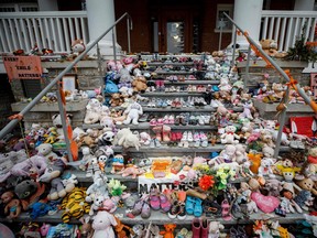 Children's shoes and stuffed animals sit on the steps as a tribute to the missing children of the former Mohawk Institute Residential School, in Brantford, Ont. in 2021.
