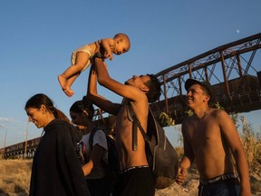 Javier Morillo from Venezuela lifts up his eight-month-old son, Said Morillo, after they crossed the Rio Grande river at the U.S.-Mexico border in Eagle Pass, Texas, on Sept. 24.