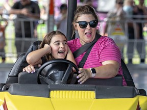 Tara Anselmini of Cambridge and her eight-year-old daughter Isabella enjoy driving the bumper cars on Sunday