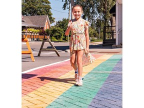 Ryder Mandryk, age 10 of Simcoe takes the first steps on the rainbow crosswalk installed on Main Street in Port Dover on Friday.