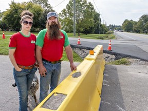 Jenny Butcher and her husband Wes Kuntz, owners of the Little Brown Cow farm market on Cockshutt Road in the County of Brant, stand by barriers blocking one of their two driveways on Thursday September 21, 2023 just south of Brantford, Ontario.