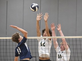 Andrew McGam (left) of the Assumption Lions gets set to spike the ball as Sajjan Mattu (centre) and Levi Hirst of the St. John's Eagles go up to block during a high school senior boys volleyball match on Thursday September 21, 2023 in Brantford, Ontario. Brian Thompson/Brantford Expositor/Postmedia Network
