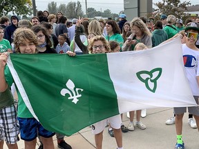 Kaiden May, left, Nico Vasanese, middle, and Nate Boulley, all 11-year-old Grade 6 pupils at Ecole Ste-Catherine, proudly display the Franco-Ontarian flag during celebrations on Monday in front of the John D. Bradley Convention Center in Chatham. (Ellwood Shreve/Chatham Daily News)