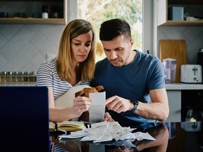 Stock photo of couple worriedly looking at bills