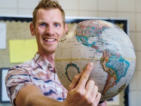 Cochrane High teacher Jander Talen poses with a globe