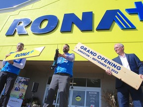 Kingston Rona+ manager Robert MacMillan uses a saw to cut a board to the officially open the store in Kingston Ont. on Thursday, Sept. 21, 2023. Helping MacMillan is Andrew Iacobucci Rona's chief executive officer and Derek Evans of the Malty Centre