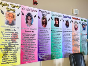 A row of colourful posters on a wall honouring victims of James Smith Cree Nation stabbings