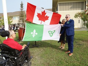 Resident Bob Neveau, left, Tanya Gil-Alfau, executive assistant at St. Joseph's Health Centre, and chaplain David Long prepare to raise the Canadian and Franco-Ontarian flags at a Franco-Ontarian Day ceremony at St. Gabriel Villa in Chelmsford, Ont. on Monday September 25, 2023. The Franco-Ontarian flag was raised to celebrate St. GabrielÕs Francophone roots.