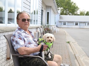 Dave Leggett and his service dog, Sandy, sit outside The Walford in Sudbury, Ont. on Wednesday September 6, 2023. Leggett, who is a resident of The Walford, is gathering signatures for a petition after learning rates at the facility are rising by about 10 per cent. That includes a rent increase along with steeper fees for services. John Lappa/Sudbury Star/Postmedia Network