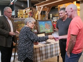 Norfolk Agricultural Hall of Fame committee members Sharon Petheram and Rob Adlam, on the left, present a certificate and medallion to Ian and Neil Anderson, sons of 2023 inductee Irene Anderson.  CHRIS ABBOTT