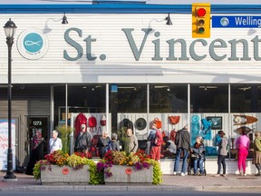 Customers line up outside St. Vincent de Paul thrift store on Wellington Street before the store's 9 a.m. opening, hoping to be get at some of the items displayed in the window.