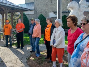 Residents form a circle around the flagpole.
