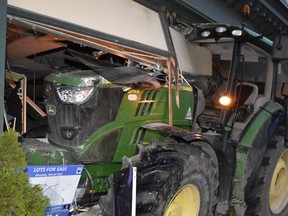 The tractor sits in the building's storefront.