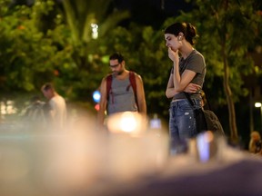 A woman stops to look at some of the candles and floral tributes at Kikar Dizengoff, on Oct. 13, 2023 in Tel Aviv, Israel.