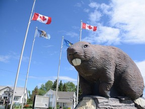 Flags wave in the wind behind the giant beaver sculpture in Beaverlodge, Alta. on Saturday, July 25, 2020.
