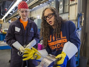17-year-old student Madison Lutzko gets help from Maggie St. Germain, a volunteer journeyman welder, to make ornamental scrolls in this file photo.