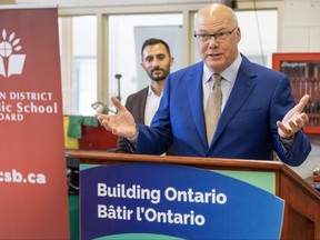 Minister of Education Stephen Lecce listens to Elgin-Middlesex-London MPP Rob Flack speak at the announcement of a new $51-million London high school that will replace Regina Mundi, which will be torn down. Photo taken on Thursday Oct. 12, 2023. Derek Ruttan/The London Free Press