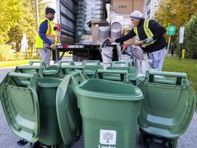 Zakariya Bagas and Mohammad Patel of Iqra Distribution assemble green bin kits for delivery in Byron on Monday, Oct. 23, 2023. The kits consist of a 45-litre container and a 10-litre kitchen container. (Mike Hensen/The London Free Press)