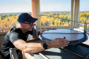 Brett shows how he records the location of smoke plumes from a lookout tower south of Fort McMurray on September 21, 2023. Photo by Emily Smith for Postmedia Network