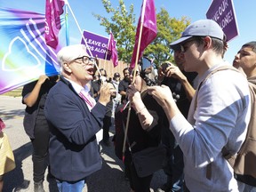 Counter-protesters get in the face of Fred Hahn, left, president of CUPE Ontario, as a large group of pro-2SLGBTQ+ rights advocates staged a day-long rally outside Victoria Park C.I. in North York on Friday, Sept. 22, 2023.