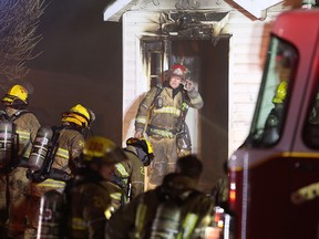 Kingston firefighters prepare to enter a house during Thursday night's house fire on Montreal Street in Kingston, Ont. on Thursday, March 29, 2023.
