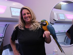Gail Mills, owner of Bermuda Tan with pet macaw, Simone