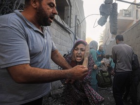 People flee Israeli air strikes on a neighbourhood in the al-Maghazi refugee camp in the central Gaza Strip on Nov. 6, amid ongoing battles between Israel and the Hamas.