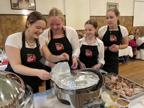 Grace McClean, from left, Janna Urbansky, Alexa Osipenko, and Marissa Pladzyk uncover the mashed potatoes at the Croatian Society of Schumacher’s 91rst Anniversary Dinner and Dance on Saturday.