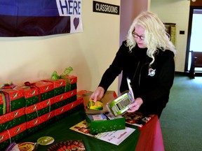 Julie Bolger, the Stratford-area coordinator for the Operation Christmas Child Shoebox program, packs a shoebox that will be delivered to a child in need in one of nine countries around the world with toys, school supplies and toiletries at the local drop-off center , Community of Christ church.