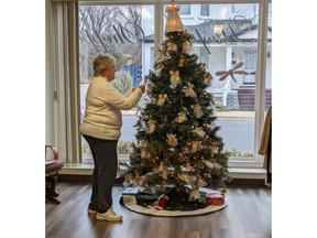 Longtime Hospice Miramichi volunteer Brenda Ouellet hangs an ornament on the Hospice Shoppe tree as part of the Angels Remembered campaign, which runs until Dec. 22.