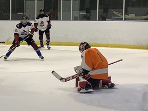 North Park Collegiate goaltender Cullen Goobie makes a save while Assumption College's Connor O'Neill looks on during AABHN boys hockey action on Tuesday at the Gretzky Centre. Expositor Staff
