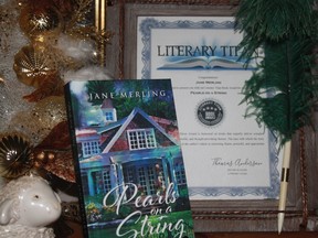 Pearls on a String sits on a mantle with an award behind it.