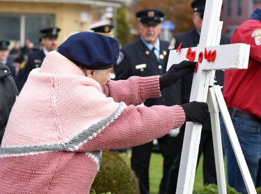 Gwen McKellar, who will turn 97 Nov. 25, pins her poppy on a cross at the Mitchell cenotaph at the conclusion of the Remembrance Day ceremony held downtown Nov. 11. The longtime Mitchell Legion branch member was part of a large crowd who attended the ceremony under favourable late fall weather conditions. ANDY BADER