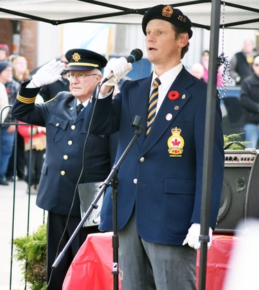 Chris Mabb, who's great-grandfather and grandfather served in WWI and WWII, sang O Canada during the Mitchell Remembrance Day service Nov. 11. Also visible is Legion Padre William Ney, who led in prayer. ANDY BADER/MITCHELL ADVOCATE