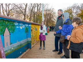 Brantford mayor Kevin Davis looks at a mural painted by Sally Slater, age 13 (left), her brother Roland (right) and mother Cindy Robertson as the City of Brantford celebrated the completion of the TH&B Crossing Bridge Revitalization project on Friday afternoon, November 10, 2023. Local artists and community members painted murals on the bridge's 112 interior steel panels during the summer