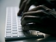 A person types on a computer keyboard in this stock photo.