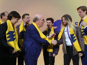 Stephen R.J. Smith, shakes hands with Queen's University engineering students following a ceremony marking Smith's $100-million donation to the university's engineering faculty in Kingston, on Thursday, Nov. 2, 2023.