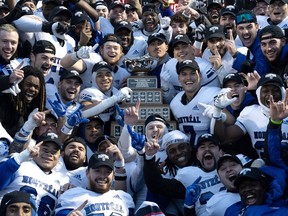 Members of the Montreal Carabins celebrate with the Vanier Cup