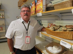 Myles Vanni, executive director of the Inn of the Good Shepherd in Sarnia, stands next to shelves in his food bank.  More demand and fewer donations has put the squeeze on food bank finances.
