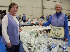 Judy Boughner (left) and Dorothy Stedman, volunteers at Treasure Mart, a huge yard sale-type event held Saturday at The Aud in Simcoe, look over some glassware.  After more than 45 years, the event has folded and will be replaced with other fundraisers for Norfolk General Hospital.