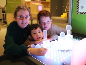 Megan Heneberry, 12, left, Nico Valdebenito, 3, and Colin Heneberry, 10, try out one of the interactive exhibits at Science North in Sudbury, Ont. on Friday November 10, 2023.