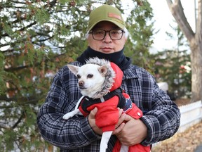 Frederic Dinne dressed his dog, Rebelle, in a warm outfit for their nippy walk in Sudbury, Ont. on Thursday November 16, 2023.