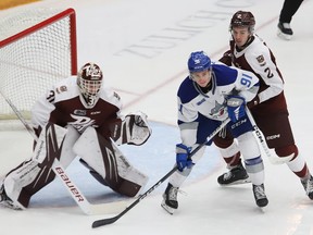 Evan Konyen, middle, of the Sudbury Wolves, and Sam Mayer, of the Peterborough Petes, battle for position in front of Petes goalie Zach Bowen during OHL action at the Sudbury Community Arena in Sudbury, Ont. on Friday November 17, 2023.
