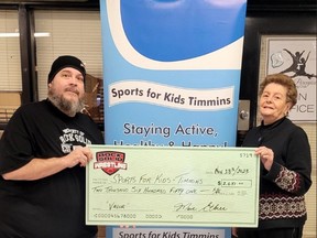 Marc Ethier, Rock Solid Wrestling Timmins promoter, presents a cheque for $2,651 to Colleen Landers with Sports for Kids Timmins.
