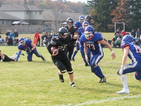 Logan Mark carries the football for Holy Trinity Titans Saturday against Simcoe Composite School Sabres. CHRIS ABBOTT
