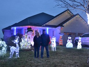 Sherrie and J.P. Parsons stand in front of their home, lit up by Christmas lights, after winning the top prize in the Avon Ward in this year's Light Up Stratford competition.