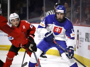 Dalibor Dvorsky (15) of Slovakia competes against Dario Sadler (21) of Switzerland during the 2023 IIHF World Junior Championship at Avenir Centre in Moncton, New Brunswick on December 31, 2022.