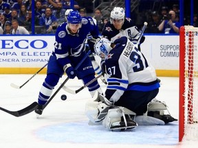 Connor Hellebuyck #37 of the Winnipeg Jets stops a shot from Brayden Point #21 of the Tampa Bay Lightning during a game at Amalie Arena on November 22, 2023 in Tampa, Florida. (Photo by Mike Ehrmann/Getty Images)